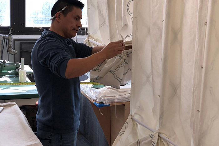 man working on curtains